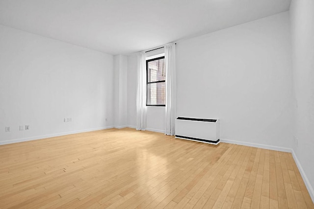 unfurnished room with baseboards and light wood finished floors