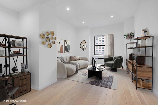 living room featuring light wood-style floors, baseboards, and recessed lighting