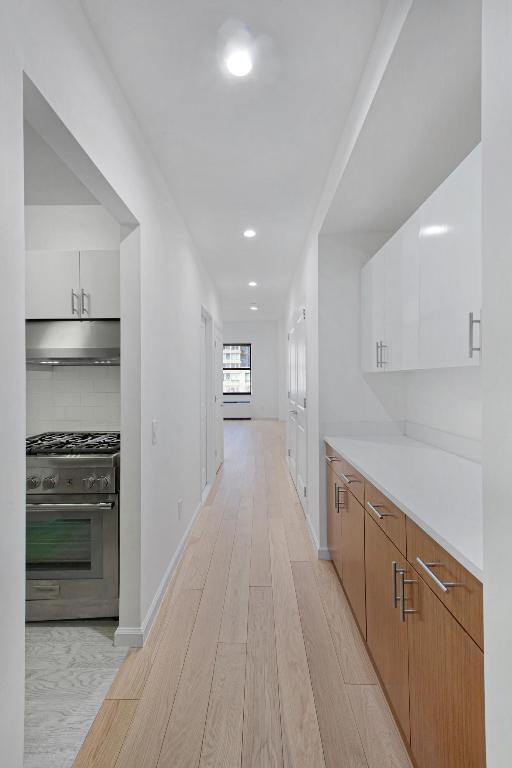 interior space featuring baseboards, light wood-style flooring, and recessed lighting