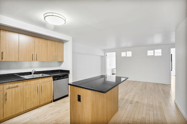 kitchen featuring a sink, dark countertops, a center island, light wood finished floors, and dishwasher