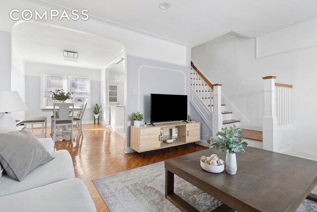 living area featuring stairs, wood finished floors, and baseboards