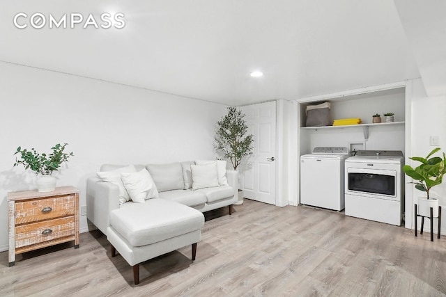 living room with light wood-style floors and independent washer and dryer