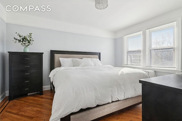 bedroom featuring dark wood finished floors and baseboards