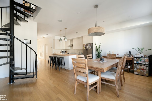 dining area with light wood-style floors, stairway, and recessed lighting