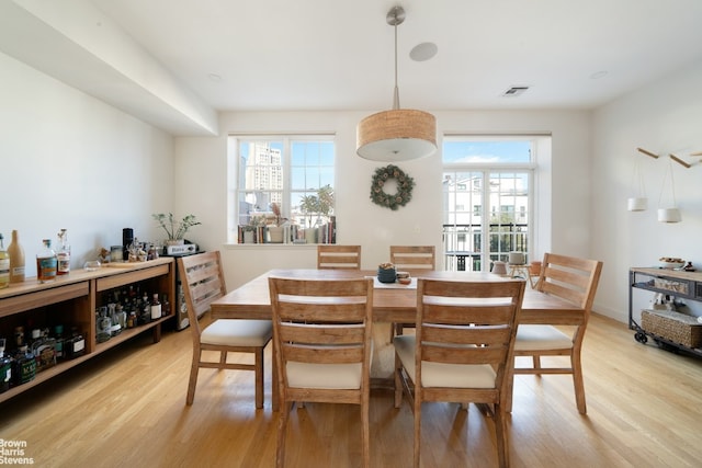 dining room with light wood finished floors and visible vents