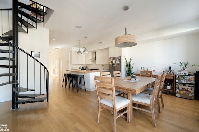 dining space featuring light wood-style flooring, stairway, and recessed lighting