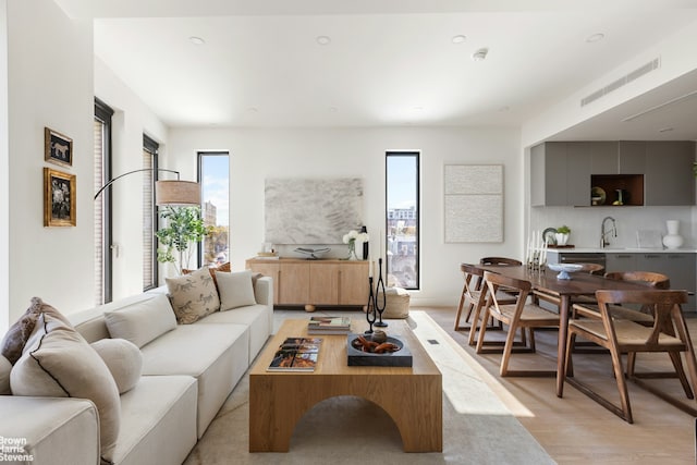 living area with recessed lighting, visible vents, and light wood-style floors