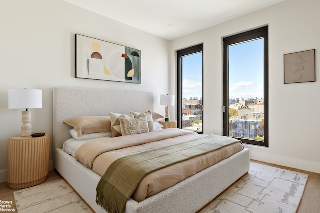 bedroom featuring light wood-style floors and baseboards