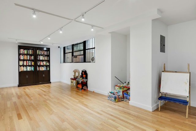 interior space featuring light wood finished floors, electric panel, and baseboards