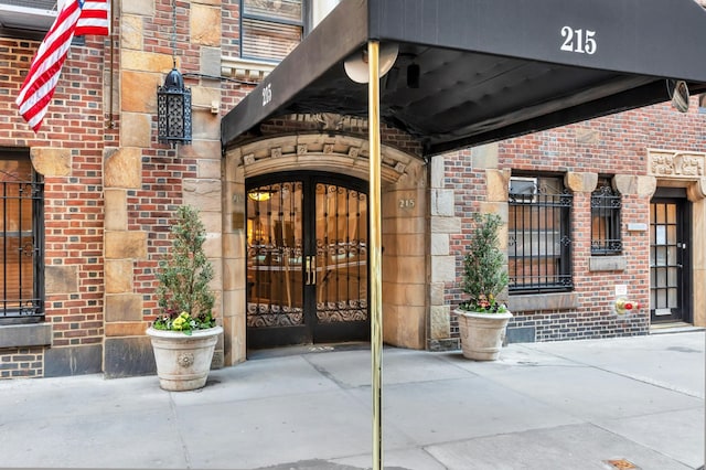 property entrance featuring french doors and brick siding