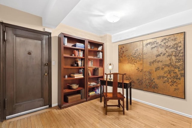 living area featuring light wood finished floors and baseboards