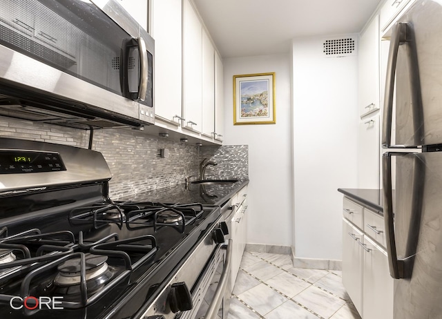 333 E 66th St Unit 9D, New York City, NY 10065 - kitchen featuring white cabinets, a sink, marble finish floor, stainless steel appliances, and baseboards