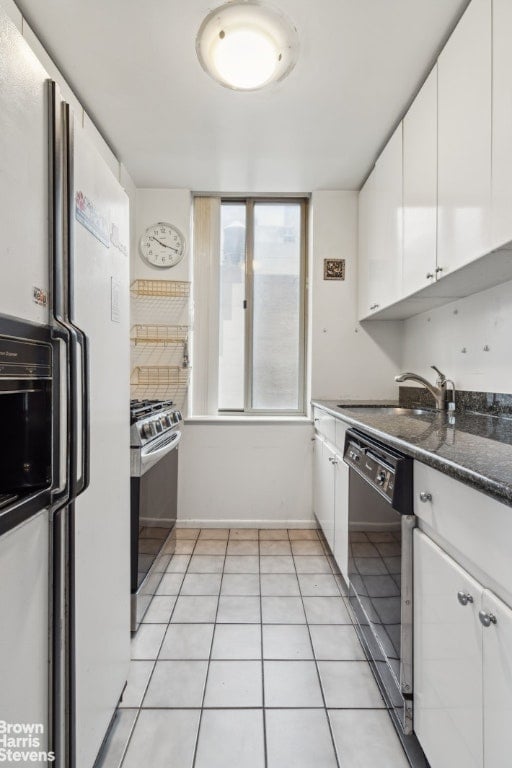 kitchen featuring black dishwasher, white cabinets, dark stone countertops, stainless steel gas range, and white fridge with ice dispenser