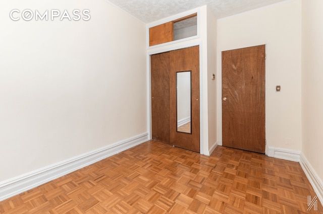 unfurnished bedroom with a textured ceiling and baseboards