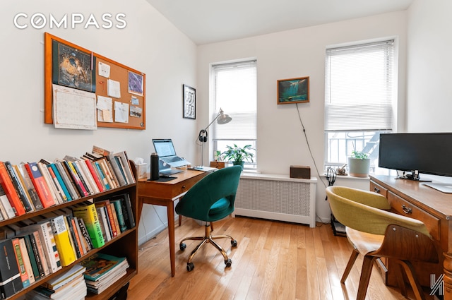 office space with radiator and light wood finished floors