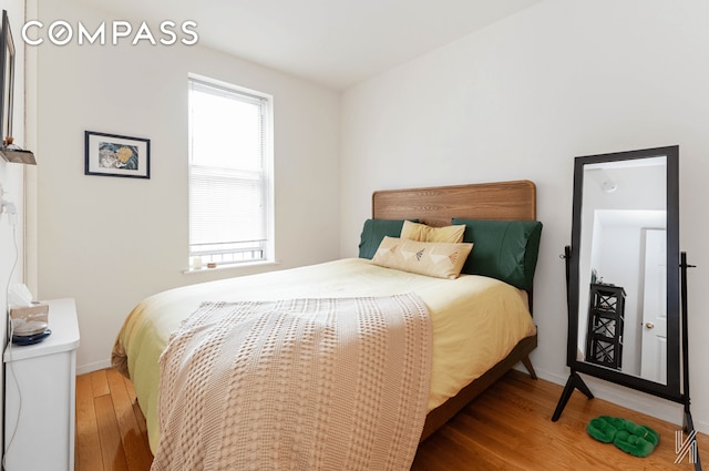 bedroom with wood finished floors and baseboards