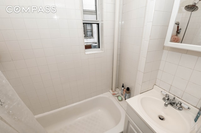 bathroom featuring shower / bath combination with curtain, tile walls, and vanity