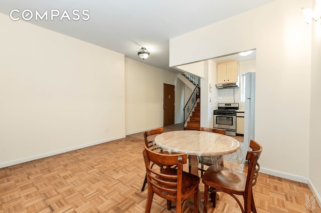 dining area featuring stairway and baseboards