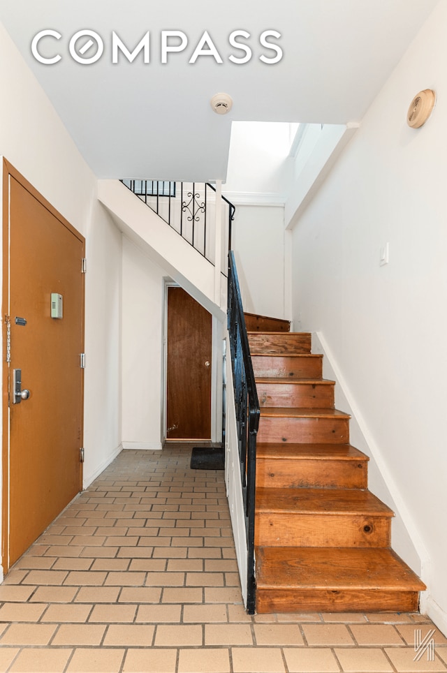 stairs with brick floor and baseboards