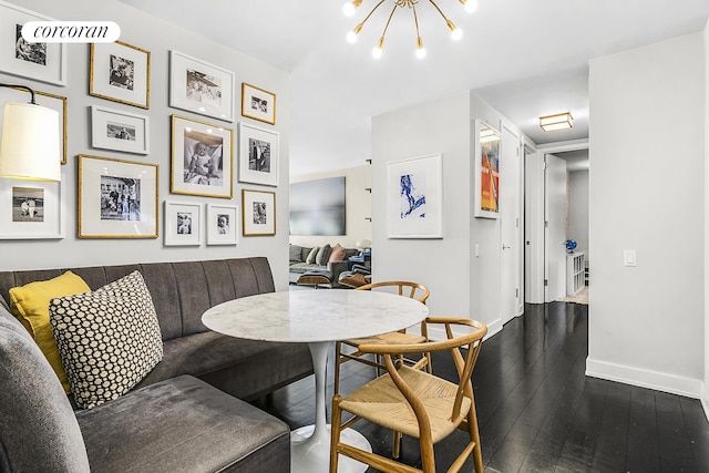 dining area featuring an inviting chandelier, dark wood-style flooring, and baseboards
