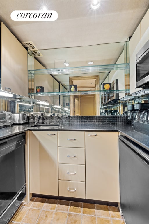 kitchen with dark countertops, visible vents, stainless steel appliances, and a sink