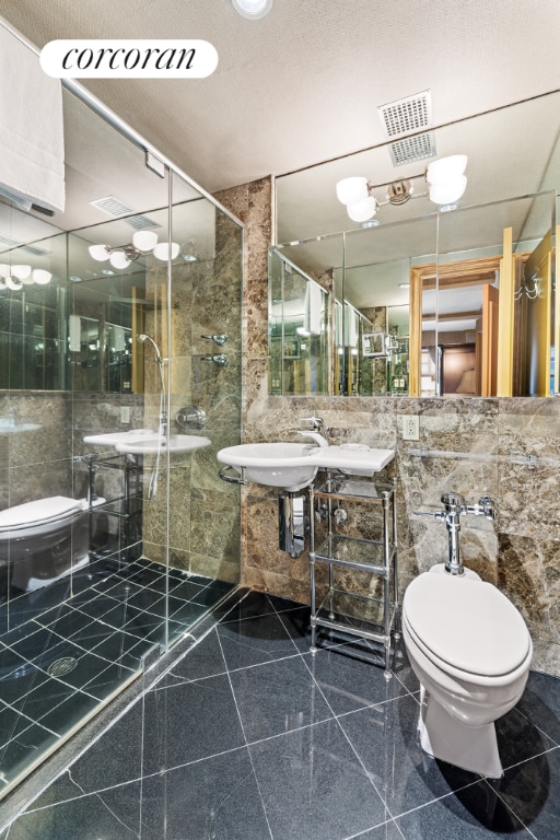 bathroom featuring a stall shower, visible vents, granite finish floor, and toilet