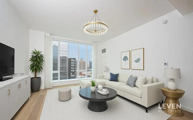 living area with light wood-type flooring, a view of city, and a chandelier