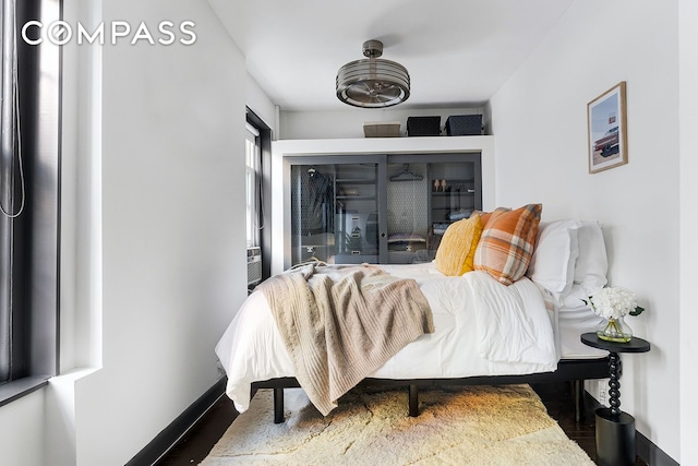 bedroom featuring wood finished floors and baseboards