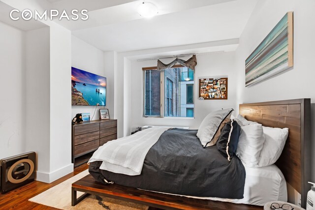 bedroom featuring baseboards and wood finished floors