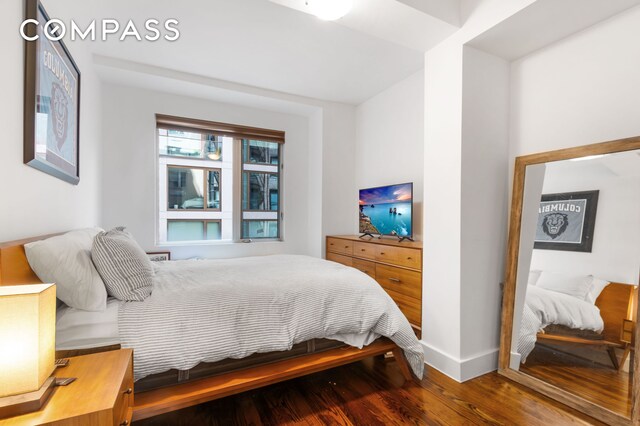 bedroom featuring baseboards and wood finished floors