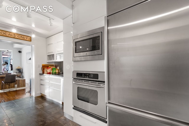 116 W 22nd St Unit 3, New York City, NY 10011 - kitchen with built in appliances, modern cabinets, white cabinets, an office area, and rail lighting
