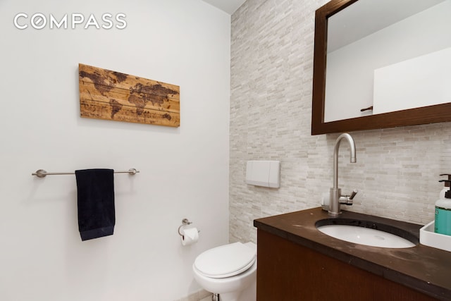 bathroom with toilet, tasteful backsplash, and vanity