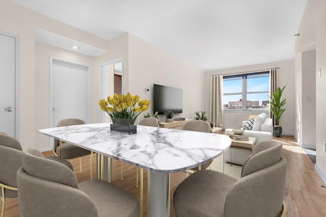 dining room with recessed lighting, baseboards, and light wood-type flooring