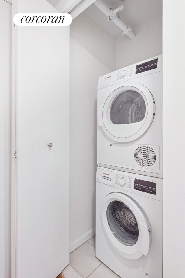 425 Main St Unit 3P, New York City, NY 10044 - washroom featuring baseboards, laundry area, light tile patterned floors, and stacked washer and clothes dryer