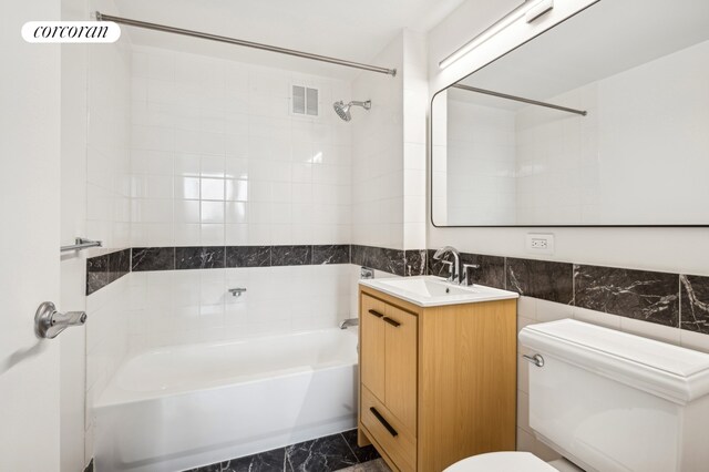 425 Main St Unit 3P, New York City, NY 10044 - bathroom with visible vents, tile walls, toilet, marble finish floor, and shower / bathtub combination