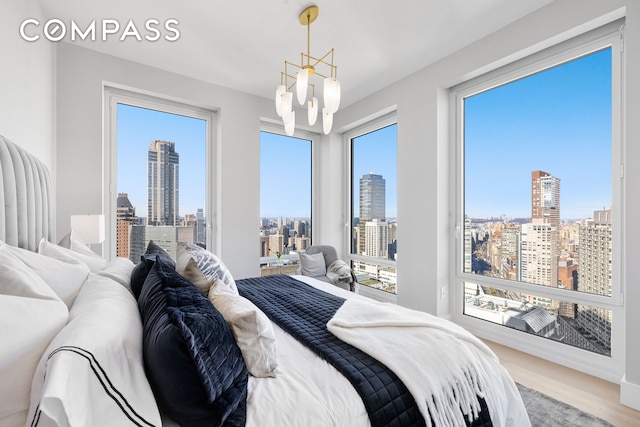 bedroom with a view of city, access to exterior, and wood finished floors