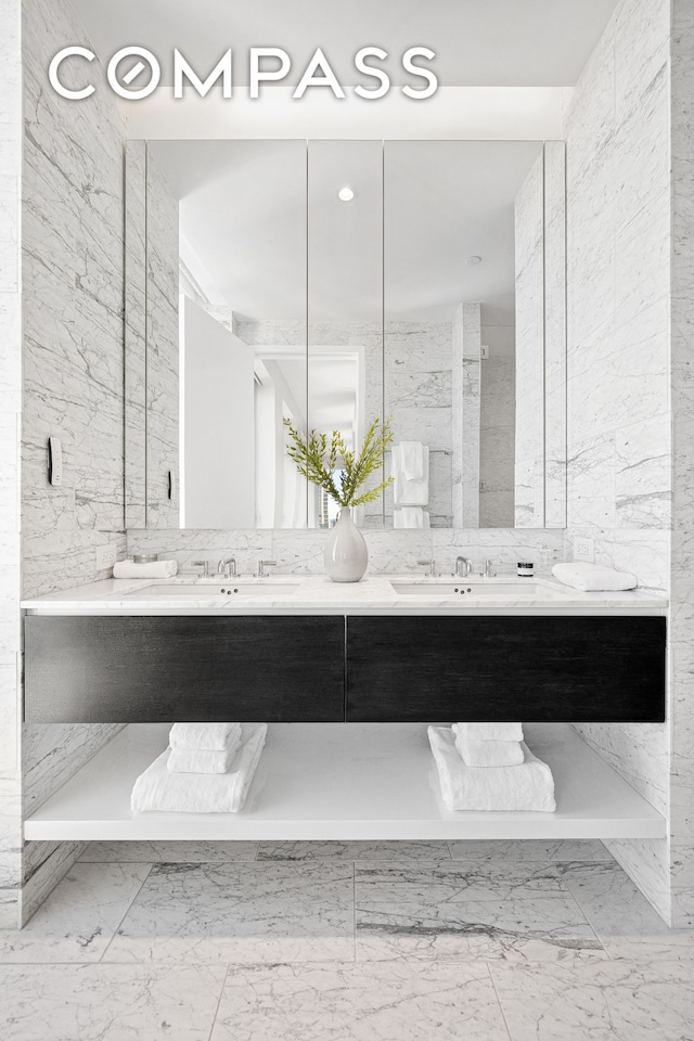 full bathroom with double vanity, a sink, and marble finish floor