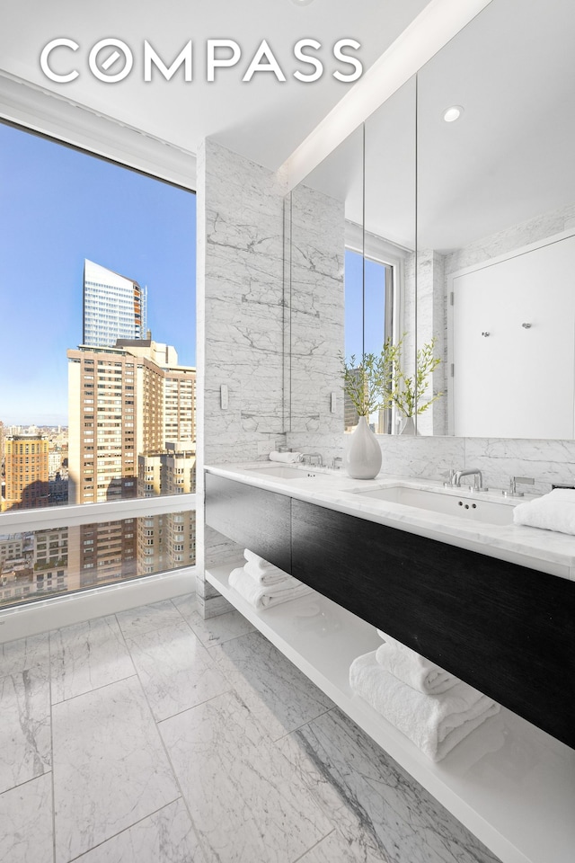 full bathroom featuring a sink, a view of city, marble finish floor, and double vanity