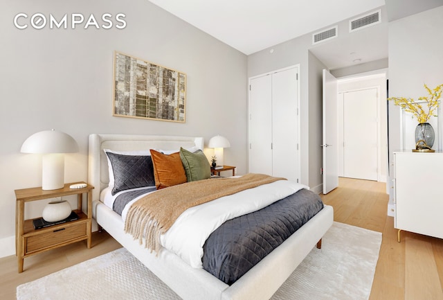 bedroom featuring baseboards, a closet, light wood-type flooring, and visible vents