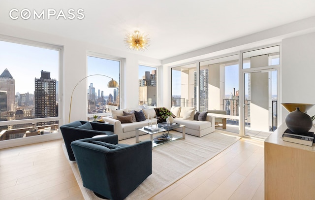 living area with light wood-style floors, a healthy amount of sunlight, and a city view