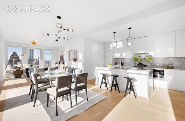 dining room featuring light wood-style floors and a notable chandelier