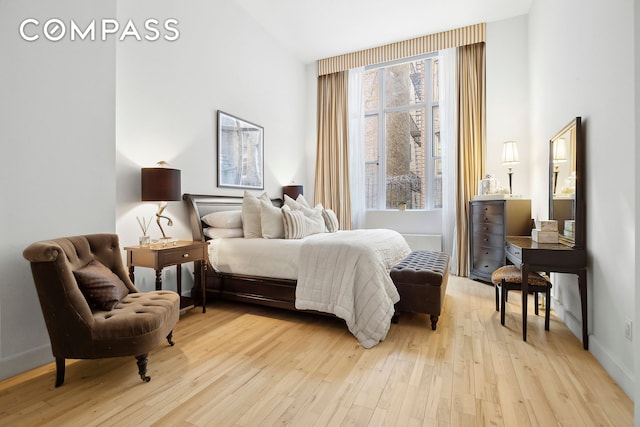 bedroom with light wood-style flooring and baseboards