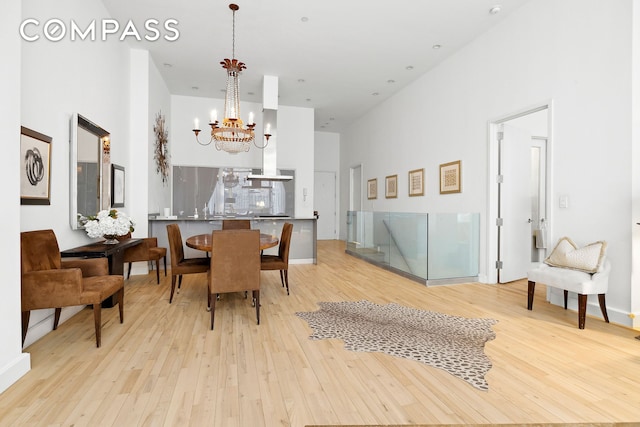 dining area featuring a high ceiling, wood finished floors, and a chandelier