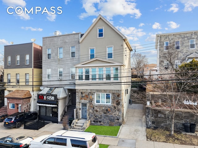 townhome / multi-family property featuring stucco siding and stone siding