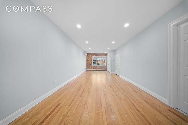 unfurnished living room with baseboards, light wood-style floors, a fireplace, and recessed lighting