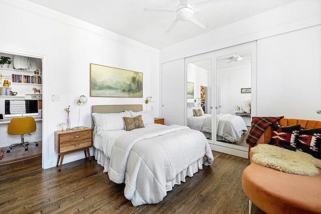 bedroom featuring a ceiling fan, dark wood-style floors, ornamental molding, built in desk, and a closet