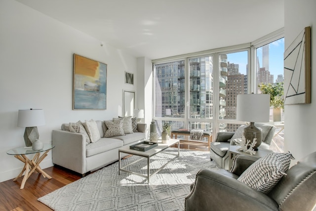 living area with a wall of windows, wood finished floors, and a city view