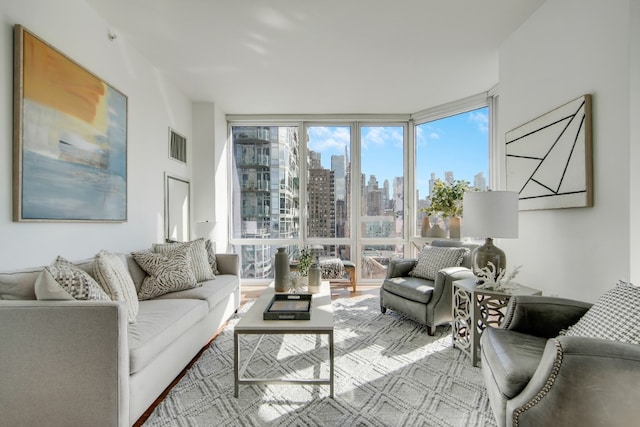 living area featuring a wall of windows, a view of city, and visible vents