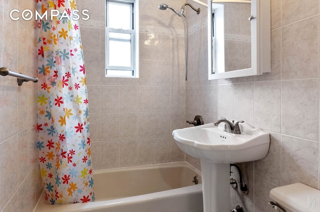 full bathroom with shower / tub combo, tile walls, and toilet