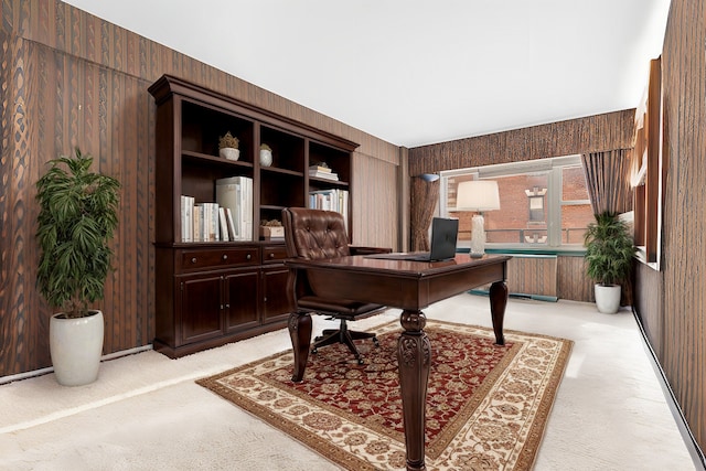 office space featuring radiator, wood walls, and light colored carpet